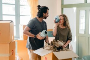 Couple with ceramic vases and a pile of cardboard boxes